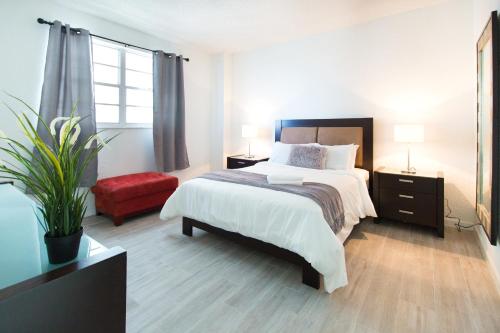 een slaapkamer met een groot bed en een rode stoel bij SIAN ocean apartments in Hollywood