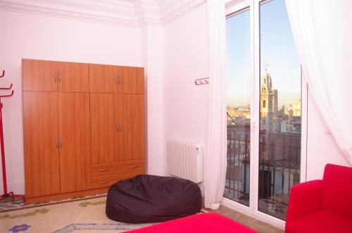 a living room with a large window and a red couch at Carlos & Ana Amplio Apartamento 4 Habitaciones Centro Valencia in Valencia