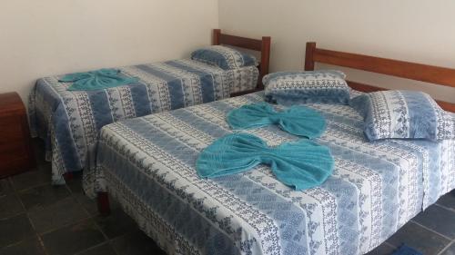 2 camas con sábanas azules y blancas con arcos en Lagoa Encantada I en Ilhéus