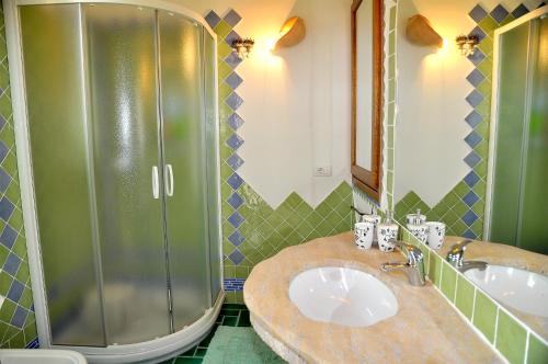 une salle de bain avec deux lavabos et une douche dans l'établissement villa i ginepri, à Budoni