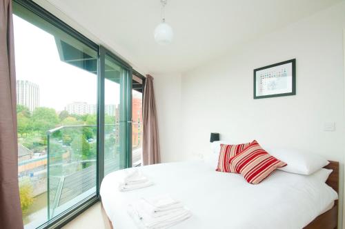 a bedroom with a white bed and a large window at Cleyro Serviced Apartments - Finzels Reach in Bristol