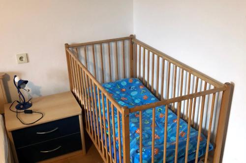 a crib with a blue blanket in a room at Ferienhaus im Wald in Edelschrott