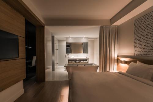 a bedroom with a bed and a kitchen in the background at Hôtel du Domaine, centre de villégiature et de congrès in Thetford Mines