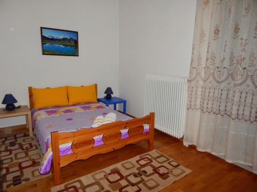 a bedroom with a bed with a wooden frame and a window at Cozy apartment for 2-5 people-Center Tripoli in Tripoli