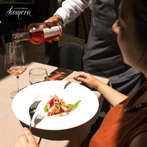a woman sitting at a table with a plate of food at Palazzo Kapece in Monopoli