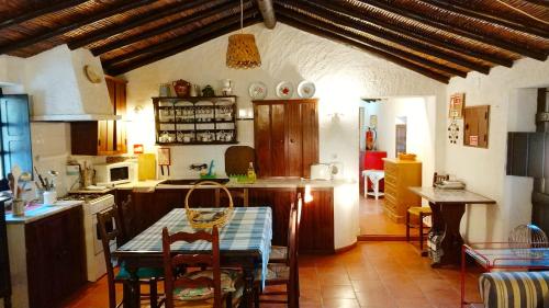 a kitchen with a table and a dining room at Monte do Altinho in Tanganheira