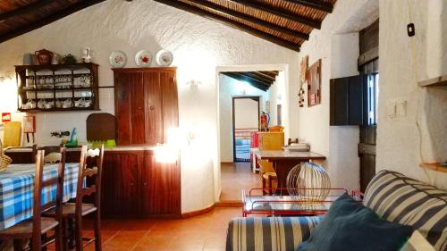 a kitchen and living room with a table and chairs at Monte do Altinho in Tanganheira