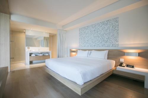 a bedroom with a large white bed and a window at Hôtel du Domaine, centre de villégiature et de congrès in Thetford Mines