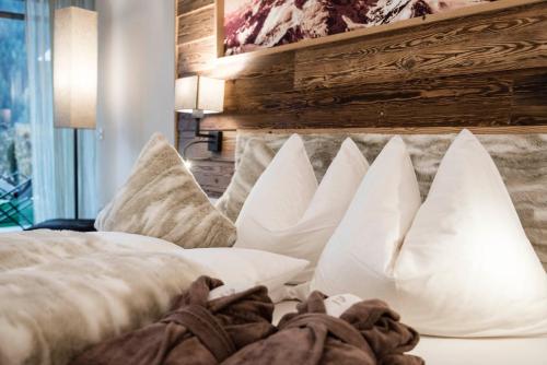 a bedroom with white pillows on a bed at Apartments Chalet Anna in Ortisei