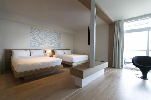 a bedroom with two beds and a desk and a chair at Hôtel du Domaine, centre de villégiature et de congrès in Thetford Mines