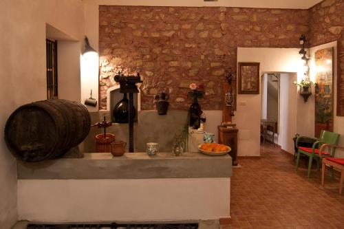 a room with a stone wall and a kitchen with a counter at B&B U Palmentu in Taormina