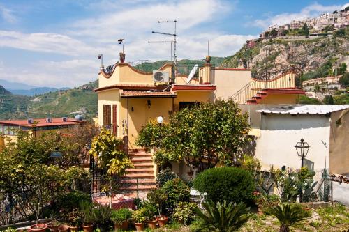 a house with stairs in front of a mountain at B&B U Palmentu in Taormina