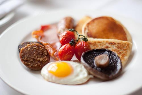 a plate of breakfast food with eggs toast and fruit at Newforge House in Moira