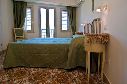 a bedroom with a bed with a blue bedspread at B&B U Palmentu in Taormina