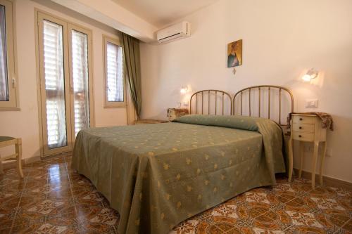 1 dormitorio con 1 cama en una habitación con ventanas en B&B U Palmentu, en Taormina