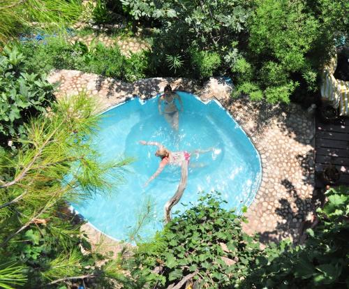 two people are swimming in a swimming pool at Turan Hill Lounge in Faralya