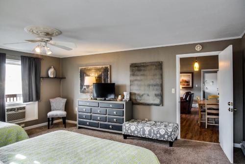 a bedroom with a bed and a dresser with a tv at Cliff Dwellers Inn in Blowing Rock