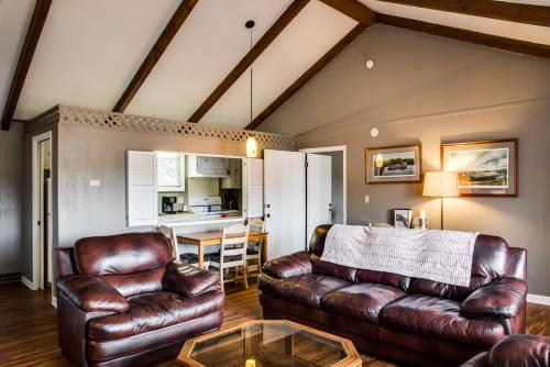 a living room with a leather couch and a table at Cliff Dwellers Inn in Blowing Rock