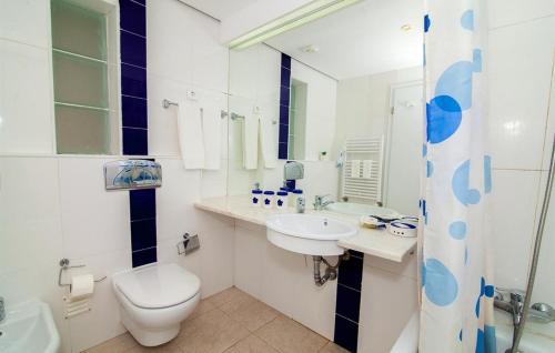 a white bathroom with a toilet and a sink at Excellent Golden Apartment in Cabanas de Tavira