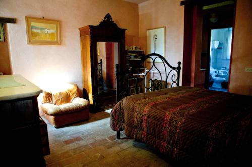 a bedroom with a bed and a chair and a table at Antico Giuncheto in Magione