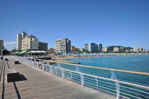 a pier with people on the beach and buildings at Clipper in Pesaro