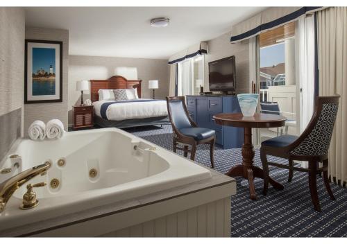 a hotel room with a tub and a bedroom at Hyannis Harbor Hotel in Hyannis