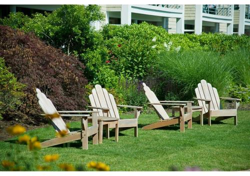 a group of three chairs sitting in the grass at Hyannis Harbor Hotel in Hyannis