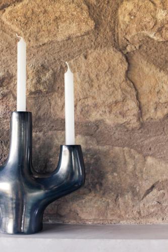 a black candle holder with two white candles at Hotel Restaurante Masía la Torre in Mora de Rubielos