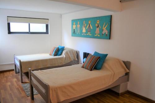 a room with two beds and a painting on the wall at 21LG Le Petit Morne in La Gaulette