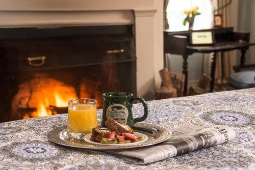 a table with a plate of food and a glass of orange juice at Caldwell House Bed and Breakfast in Salisbury Mills