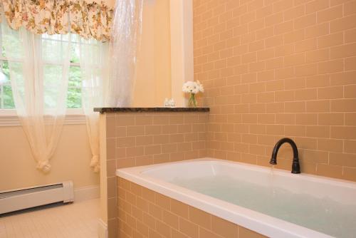 a bathroom with a tub and a window at Caldwell House Bed and Breakfast in Salisbury Mills