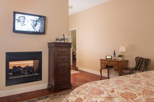 a bedroom with a fireplace and a tv on the wall at Caldwell House Bed and Breakfast in Salisbury Mills