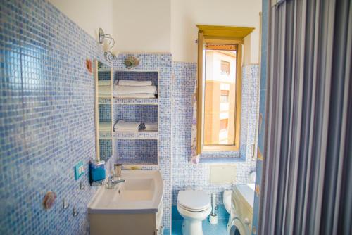 リド・ディ・オスティアにあるB&B Calypsoの青いタイル張りのバスルーム(トイレ、シンク付)