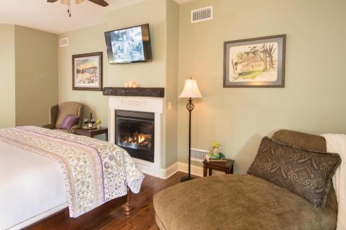 a bedroom with a fireplace and a bed and a chair at Caldwell House Bed and Breakfast in Salisbury Mills