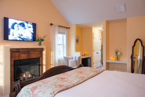 a bedroom with a bed with a fireplace and a television at Caldwell House Bed and Breakfast in Salisbury Mills