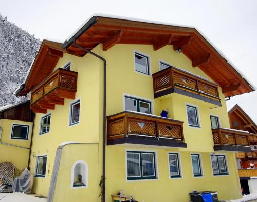 a yellow building with wooden balconies on it at Appartement Tirol in Biberwier
