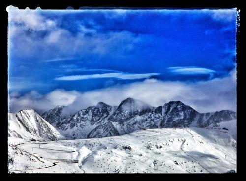 a view of a mountain range with snow and clouds at Hotel Casado in Pas de la Casa