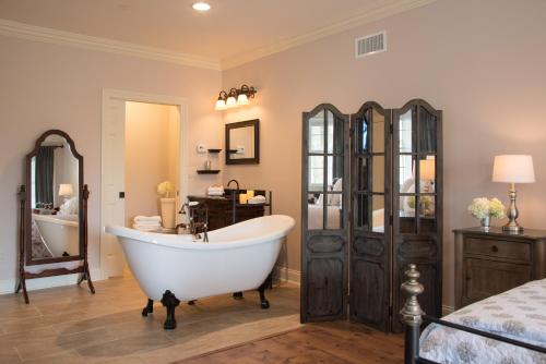 a bathroom with a bath tub and a bedroom at Caldwell House Bed and Breakfast in Salisbury Mills