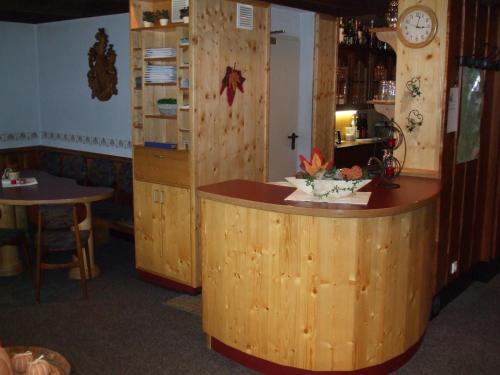 a bar in a restaurant with a clock on the wall at Hotel-Restaurant Zum Dorfkrug in Winterberg