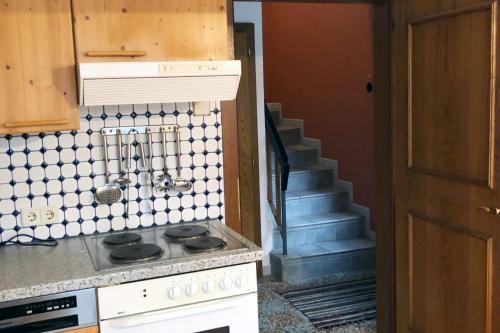 a kitchen with a stove and a staircase at Ferienhaus im Wald in Edelschrott