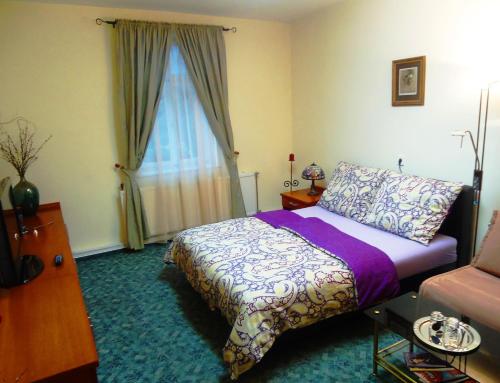 a bedroom with a bed and a window at Buda Panzió in Győr