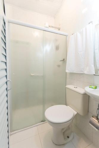 a bathroom with a toilet and a glass shower at Hotel Paraiso in São Paulo