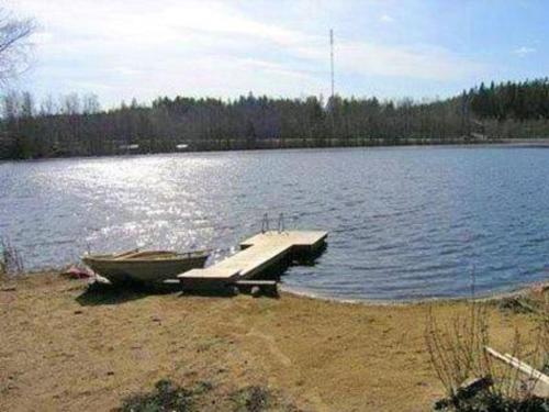 a boat sitting on the shore of a lake at Holiday Home Mustikka by Interhome in Röylä