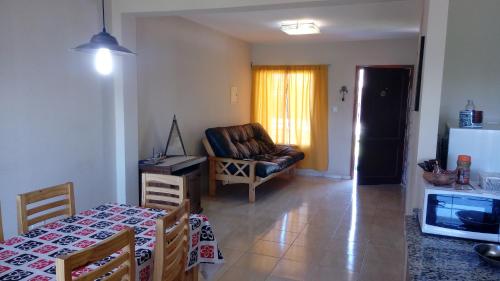 eine Küche und ein Wohnzimmer mit einem Tisch und einem Sofa in der Unterkunft Duplex Kirara in Santa Lucía