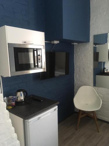 a kitchen with a microwave and a white chair at Hotel Sleep at Rauma in Rauma