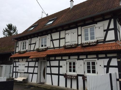 a white and black house with white windows and a roof at Quartier vert in Hunspach