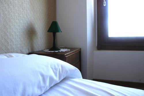 a bedroom with a bed and a lamp on a nightstand at Agriturismo Prato Grande in Loiano