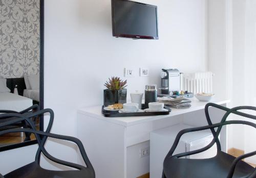 a table with two chairs and a tv on a wall at Viasparano B&B in Bari