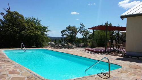 a blue swimming pool in a yard with a patio at Top of the Hill RV Resort & Cabins in Waring