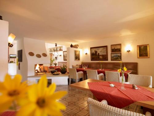 a dining room with a table and a living room at Landhaushotel Hof Wasserkuppe in Poppenhausen